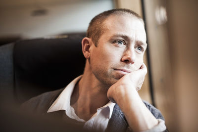 Thoughtful mature businessman sitting in train