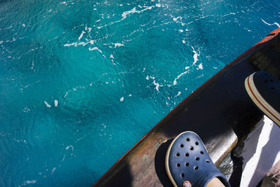 Low section of child standing in boat on sea