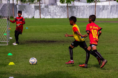 Boys playing soccer on field