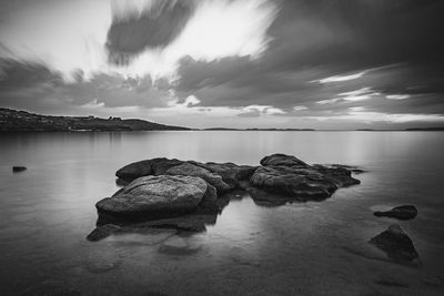 Rocks on sea shore against sky
