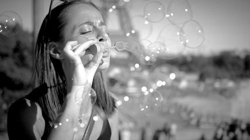 Close-up of woman playing with bubble wand