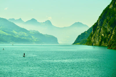 Scenic view of sea and mountains against sky