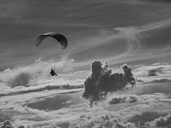 Low angle view of person paragliding against sky