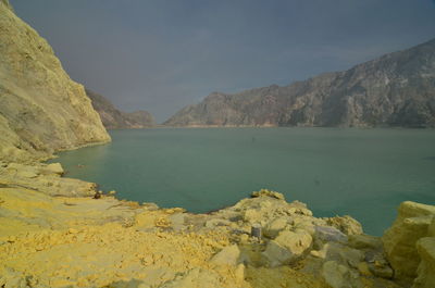 Scenic view of sea and mountains against sky