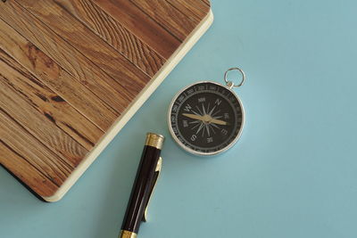 Directly above shot of navigational compass on blue background