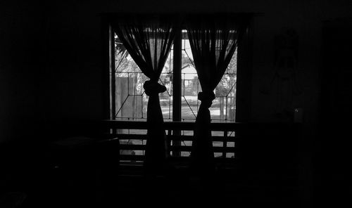 Silhouette people seen through glass window in building