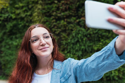 Young businesswoman with redhead taking a selfie