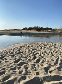 Scenic view of beach against clear blue sky