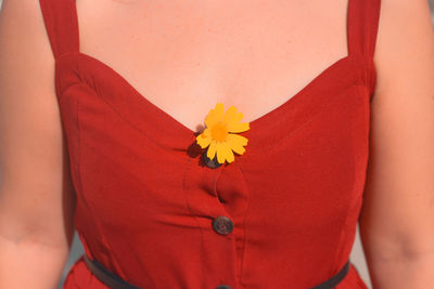 Close-up of woman breast with yellow flower head