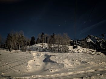 Snow covered landscape against sky