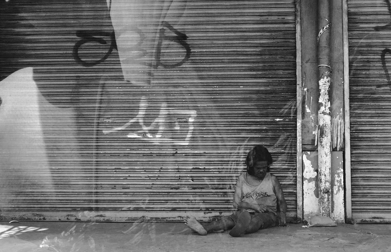 shutter, sitting, built structure, corrugated iron, day, one person, young adult, outdoors, people, adult, adults only