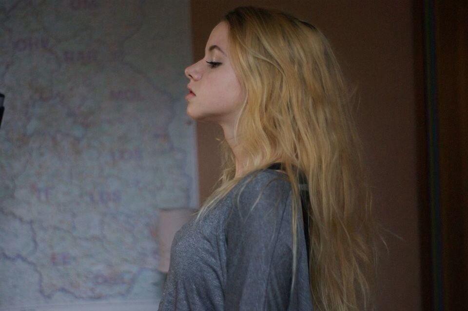 long hair, young adult, lifestyles, young women, person, headshot, casual clothing, contemplation, waist up, leisure activity, blond hair, brown hair, front view, indoors, human hair, looking away, side view