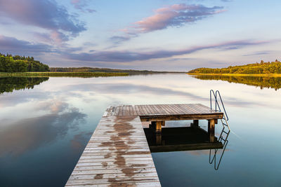 Pier over lake against sky during sunset