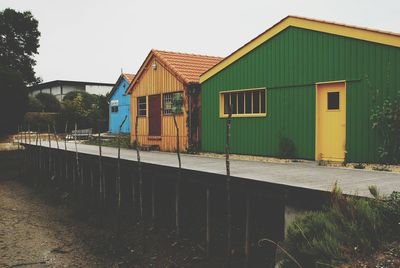 Exterior of houses by building against clear sky