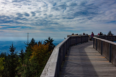 People on bridge against sky