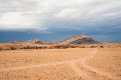 Scenic view of desert against sky with mountain