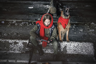 Full length of woman holding dog during winter