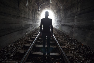 Silhouette man walking in tunnel