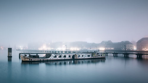 Boats moored in river against clear sky