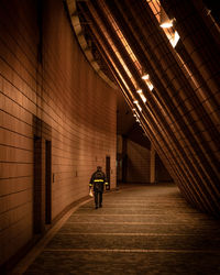 Rear view of man walking in tunnel