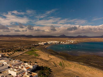 Aerial view of city by sea against sky