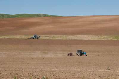 View of tractor on field against clear sky