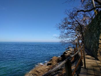 Scenic view of sea against clear blue sky during sunny day