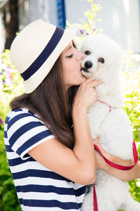 Midsection of woman with dog in hat