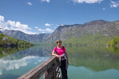  woman standing by lake against sky