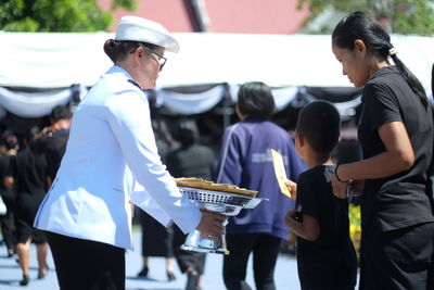 Woman giving cards to people