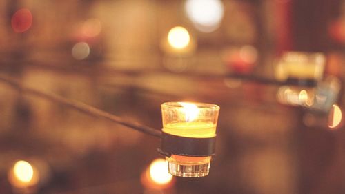 Close-up of illuminated tea light candle on table