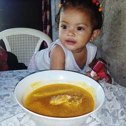 Close-up portrait of cute girl sitting on table