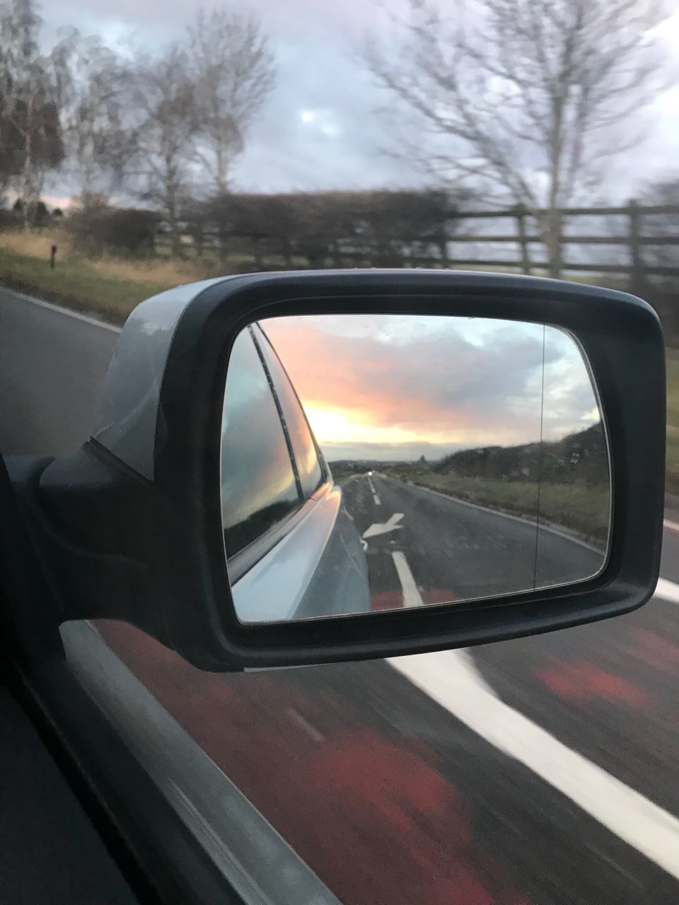 REFLECTION OF ROAD ON SIDE-VIEW MIRROR