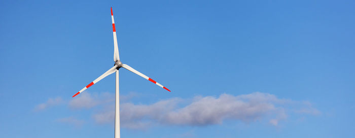 Low angle view of windmill against blue sky