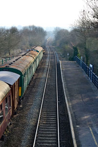 Railroad tracks amidst trees against clear sky