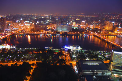 Illuminated cityscape against sky at night