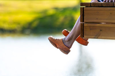 Low section of person relaxing on wood