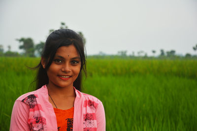 Portrait of smiling young woman in field