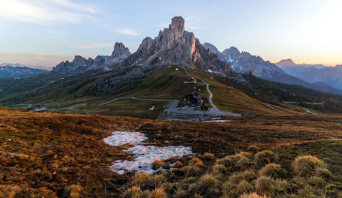 Scenic view of landscape against mountains and sky during sunset