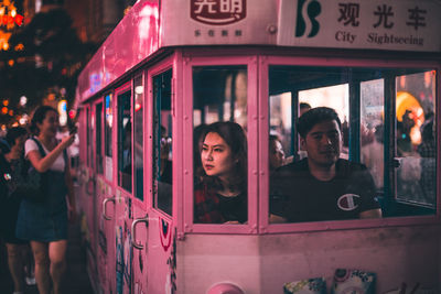 Portrait of people standing against graffiti at night