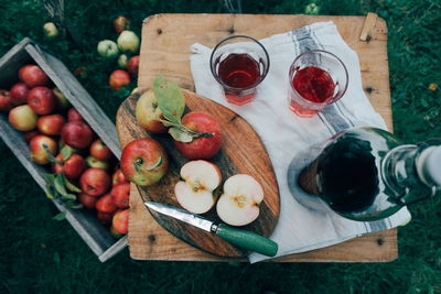 High angle view of apples with drink on wooden table in farm