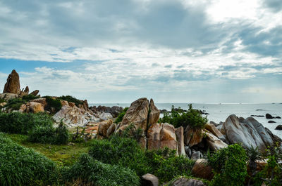 Rocks by sea against sky