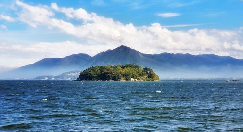 Scenic view of sea and mountains against sky