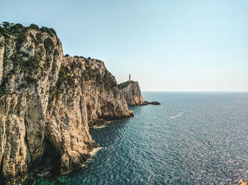 Rock formations by sea against sky