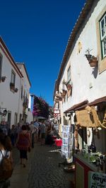 People on street amidst buildings in city