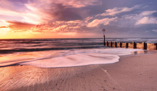 Scenic view of beach against sky during sunset