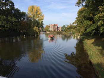 Scenic view of lake against sky in city