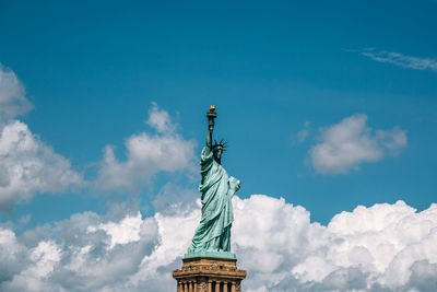 Low angle view of angel statue against cloudy sky