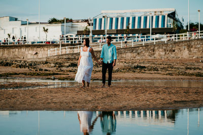 Rear view of couple walking on water
