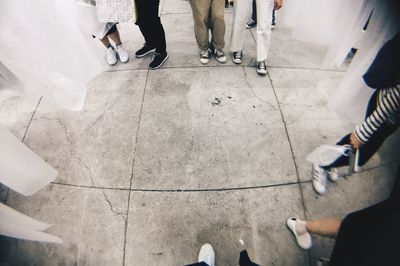 Low section of people standing on tiled floor